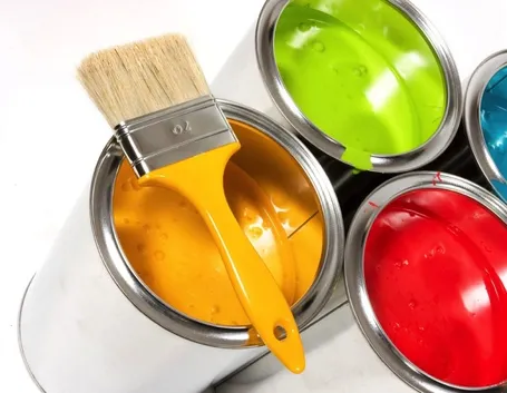 Contenitori di pittura di colori diversi con un pennello