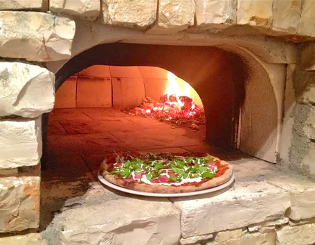 Pizza nel forno a legna