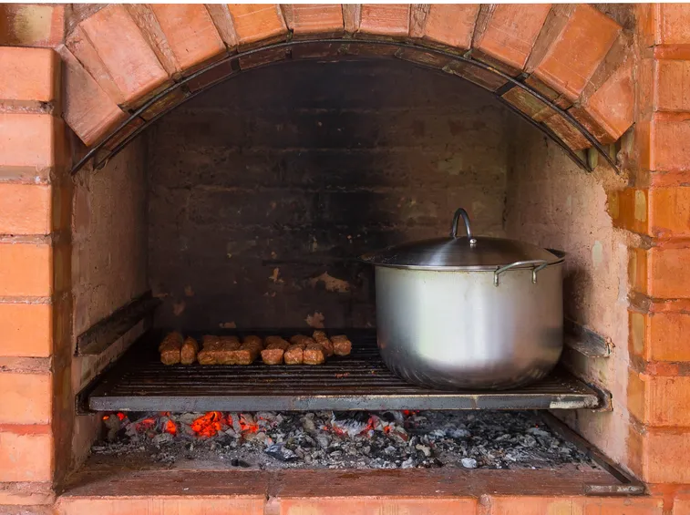 cottura di carne sulla brace del camino