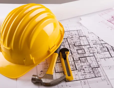 Casco da lavoro sopra una planimetria di un edificio