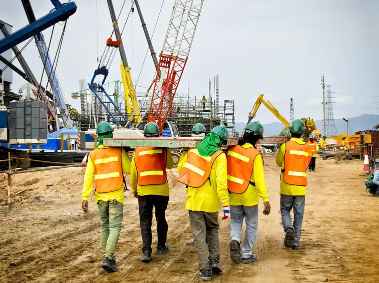 Operai in cantiere sicuro con elmetti
