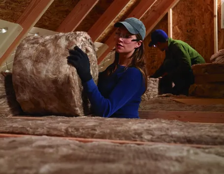 Posa di lana di roccia in un tetto in legno