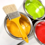 Contenitori di pittura di colori diversi con un pennello