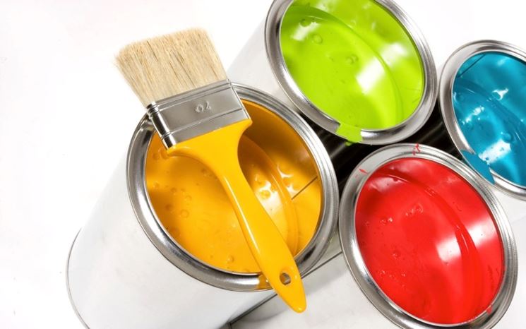 Contenitori di pittura di colori diversi con un pennello